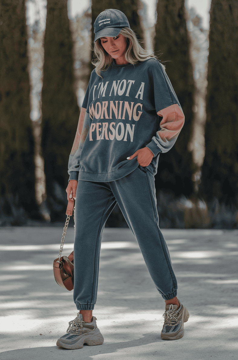 Young woman in casual oversized sweatshirt and joggers, enjoying the outdoors among evergreen trees.