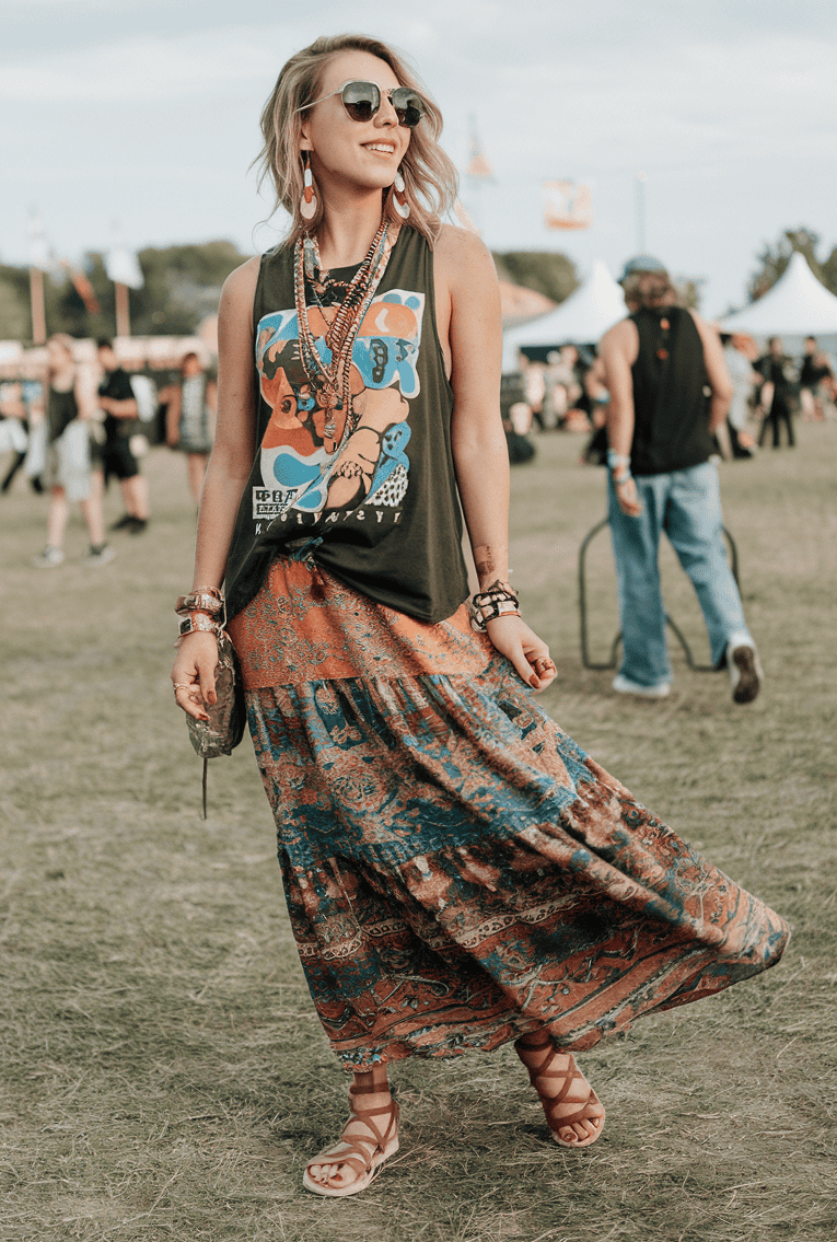 Young woman radiates joy at a colorful music festival, showcasing bohemian style and carefree spirit.