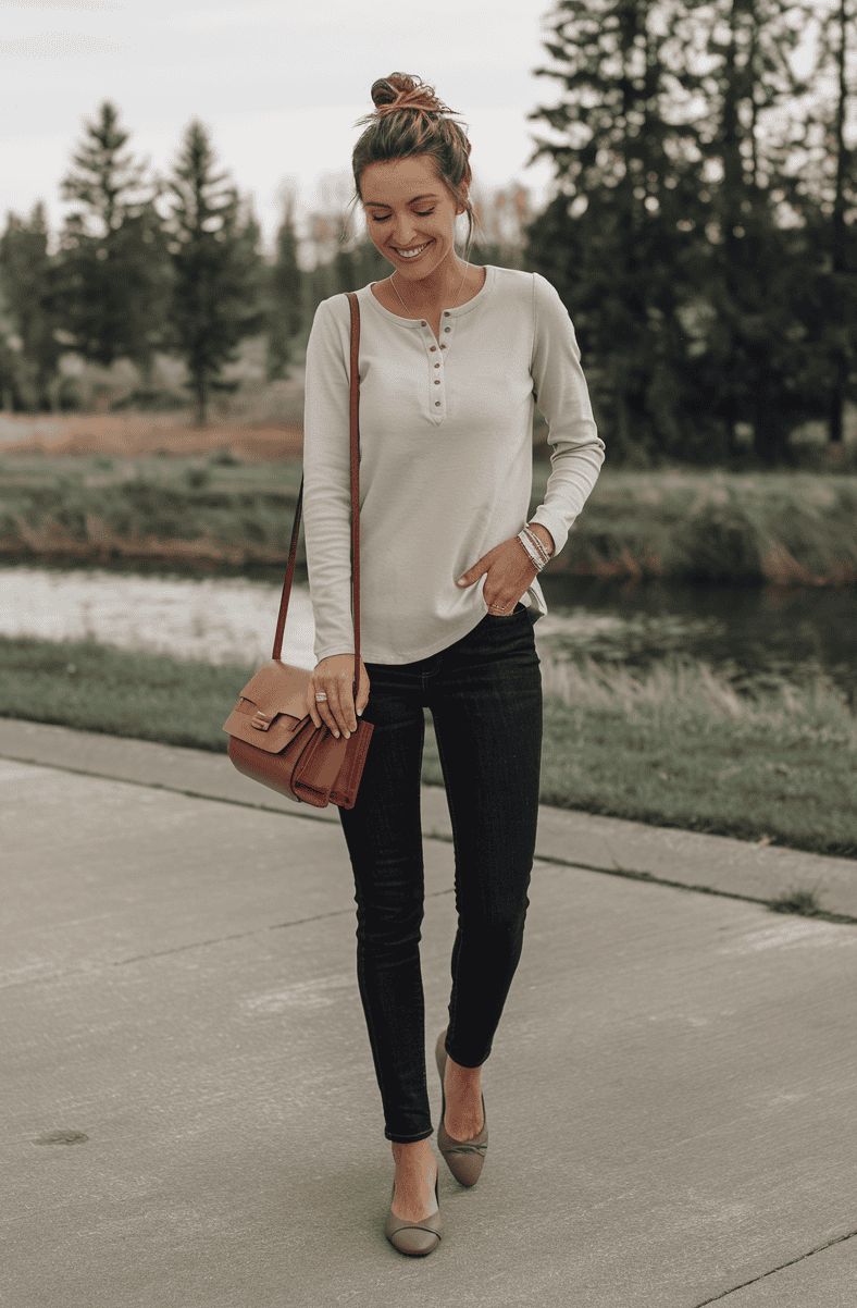 Woman in casual elegance walking by serene water in nature, wearing a beige top and jeans.