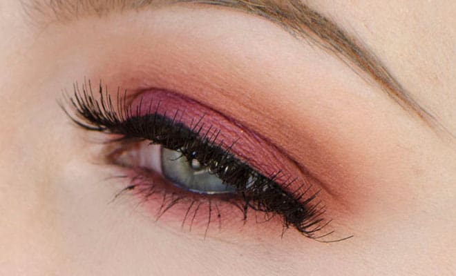 Stunning eye makeup for blue eyes with plum and peach eyeshadow and voluminous lashes.