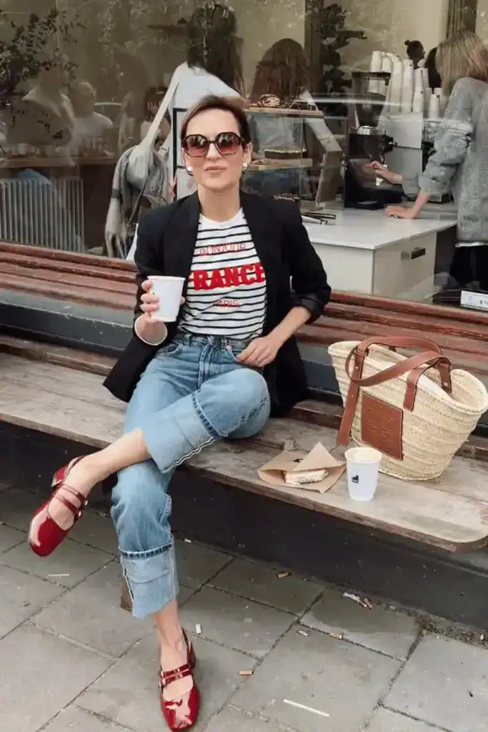 women weaing a black blazer, red Mary janes, white shirt