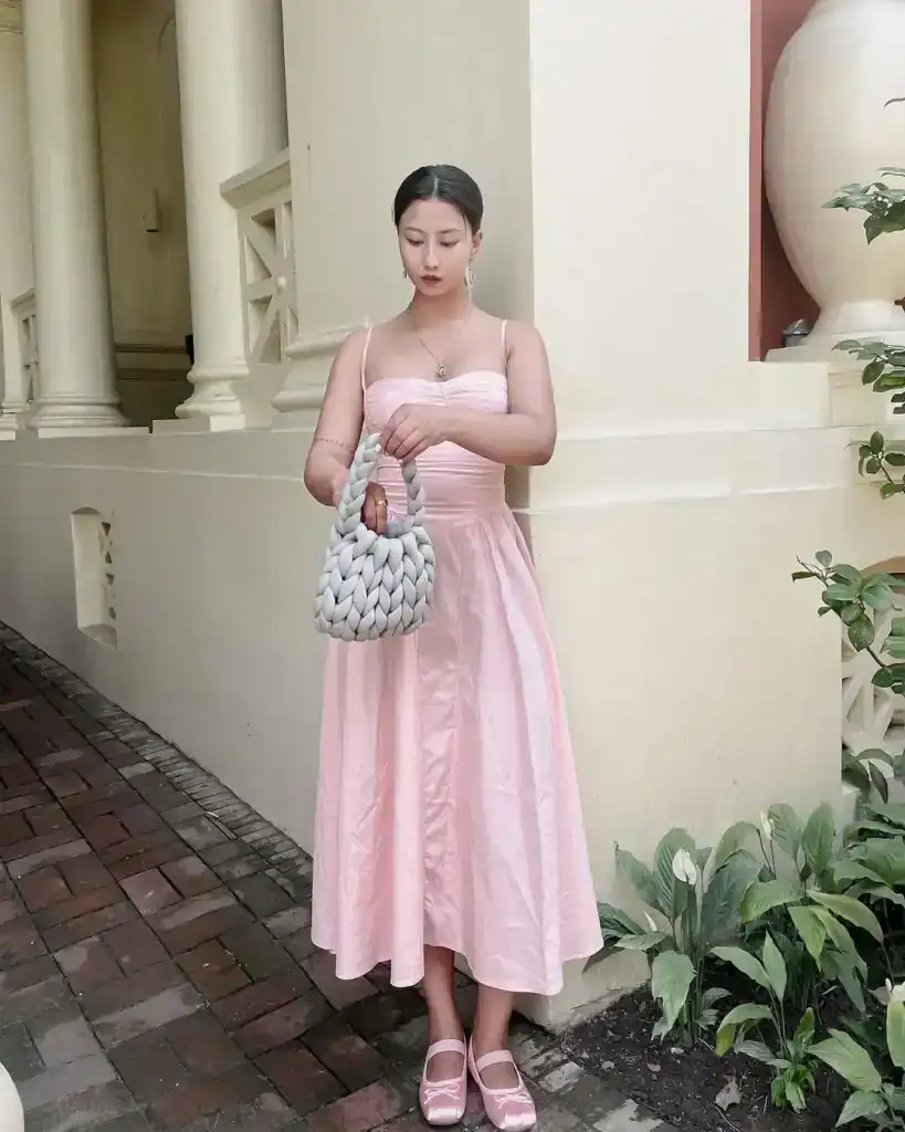 woman wearing a long pink dress with ballet shoes