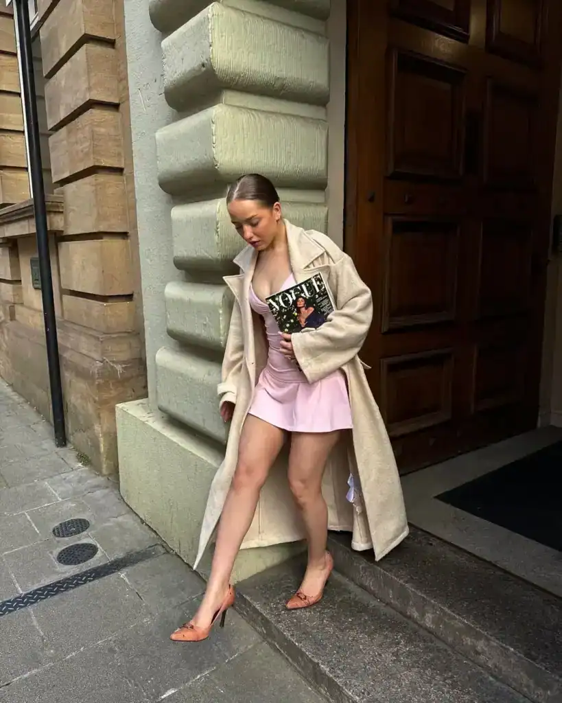 woman wearing a pretty short mini dress with a beige parka coat