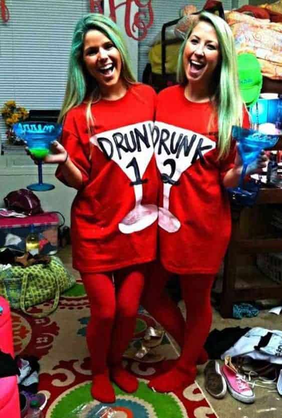 Two friends in matching Drunk 1 and Drunk 2 costumes with colorful drinks at a party.