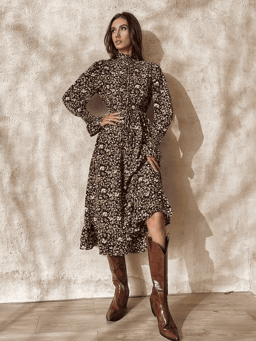 Boho floral midi dress with long sleeves and brown knee-high boots, modern fashion photoshoot.