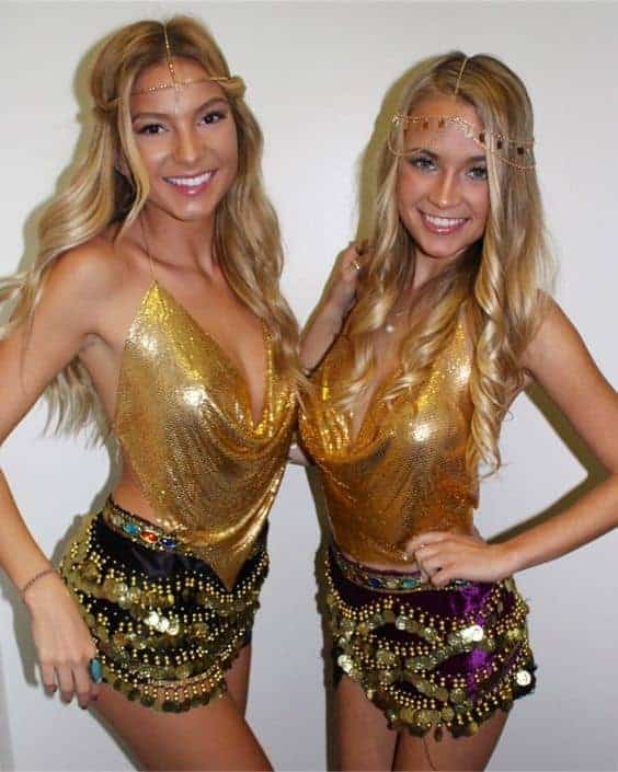 Two best friends in matching belly dancer Halloween costumes posing together and smiling.