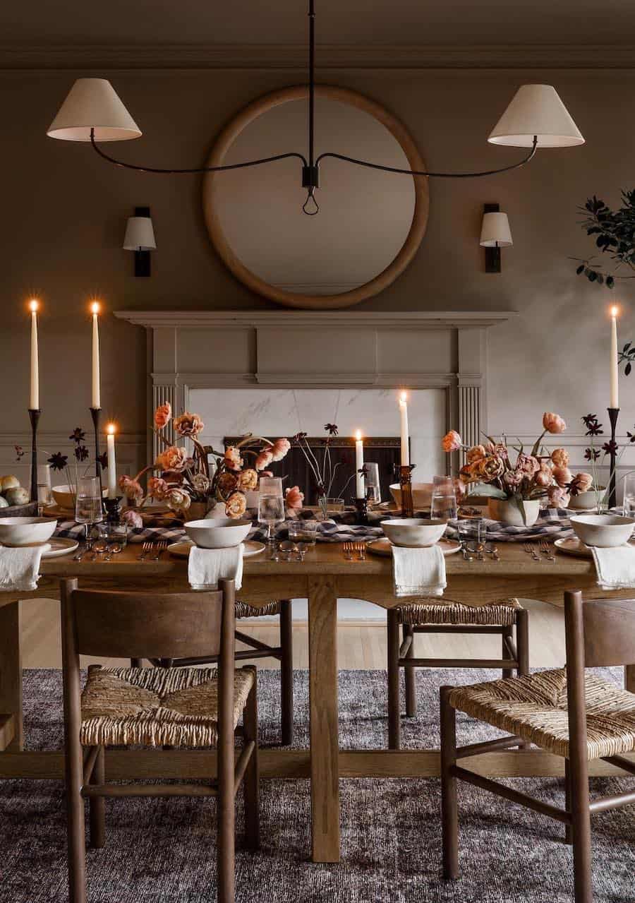 a dining table with a fall-inspired centerpiece featuring fall florals, candles, and plaid prints